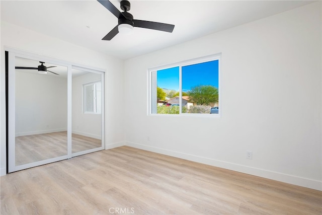 unfurnished bedroom featuring light wood-type flooring, a closet, and ceiling fan