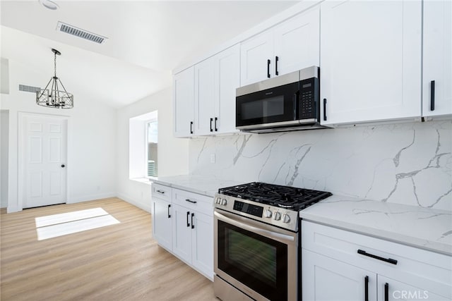 kitchen featuring decorative backsplash, light wood-type flooring, white cabinetry, and appliances with stainless steel finishes