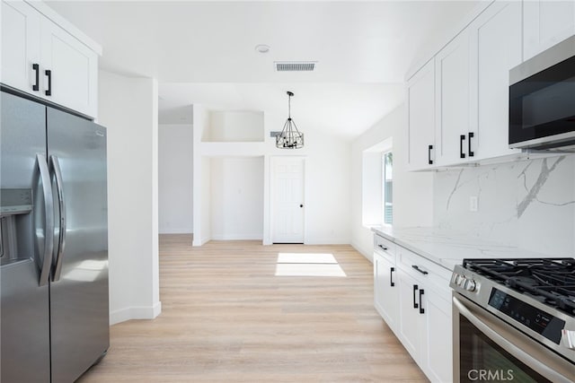 kitchen featuring light stone counters, light hardwood / wood-style flooring, white cabinets, and stainless steel appliances