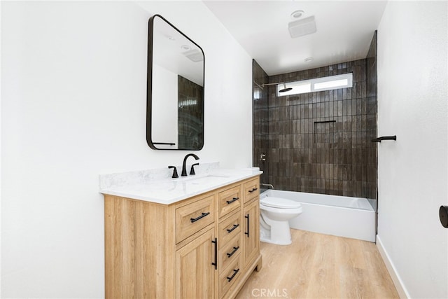 full bathroom with wood-type flooring, vanity, toilet, and tiled shower / bath