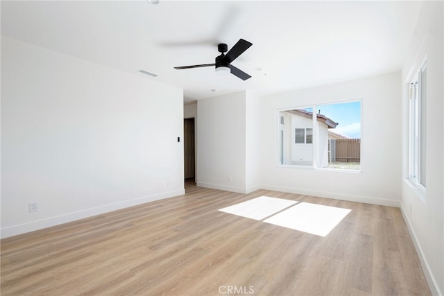 empty room with ceiling fan and light hardwood / wood-style floors