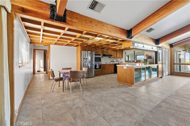 kitchen with beamed ceiling, appliances with stainless steel finishes, light tile floors, and a breakfast bar