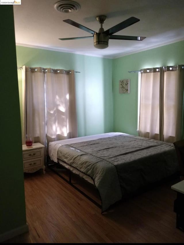 bedroom featuring ornamental molding, ceiling fan, and dark hardwood / wood-style flooring