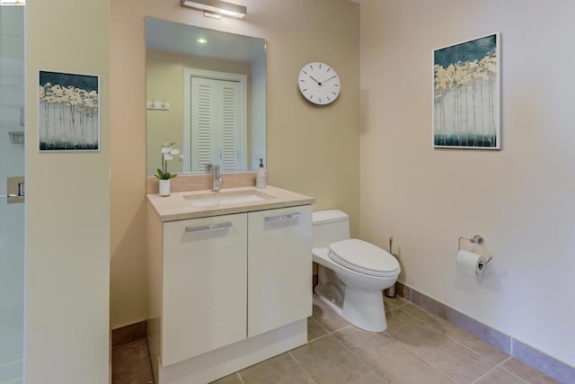 bathroom with tile floors, large vanity, and toilet