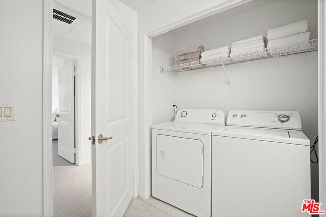 washroom featuring light carpet and washing machine and dryer