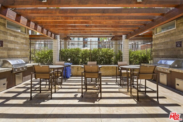 view of patio / terrace with a pergola, an outdoor kitchen, and area for grilling