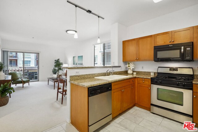 kitchen featuring sink, light stone countertops, kitchen peninsula, and stainless steel appliances