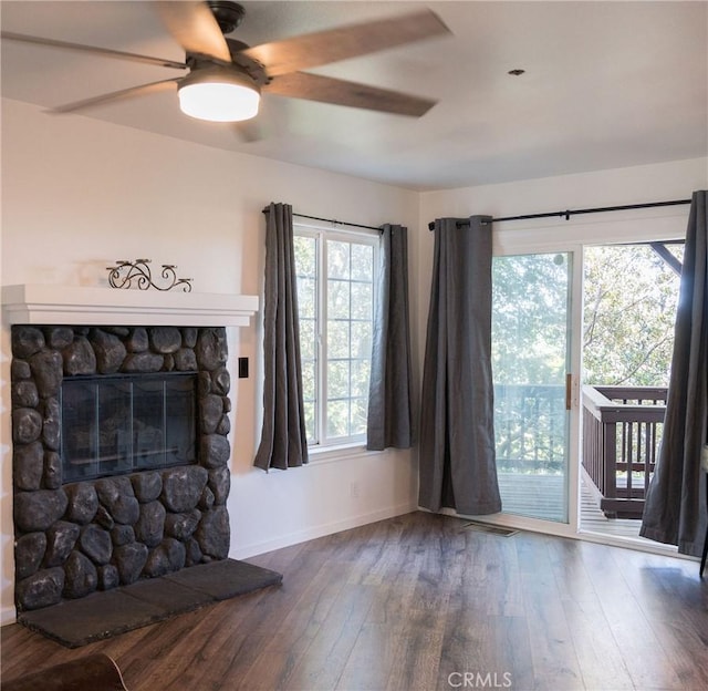 unfurnished living room featuring hardwood / wood-style floors, ceiling fan, and a fireplace