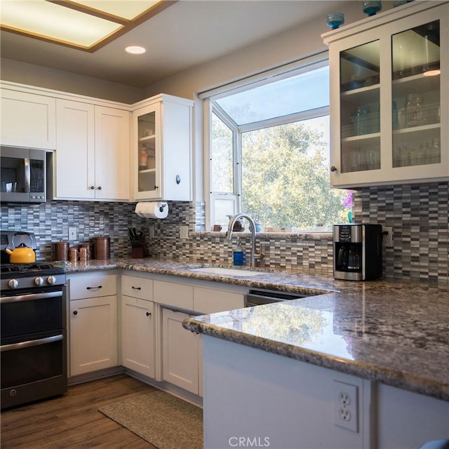 kitchen featuring tasteful backsplash, sink, white cabinets, and appliances with stainless steel finishes