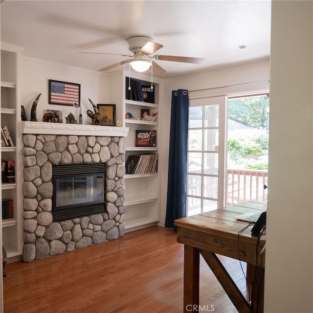 living room with a fireplace, ceiling fan, hardwood / wood-style floors, and crown molding