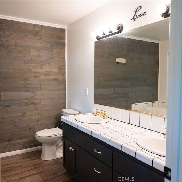 bathroom featuring vanity, wood walls, toilet, and wood-type flooring