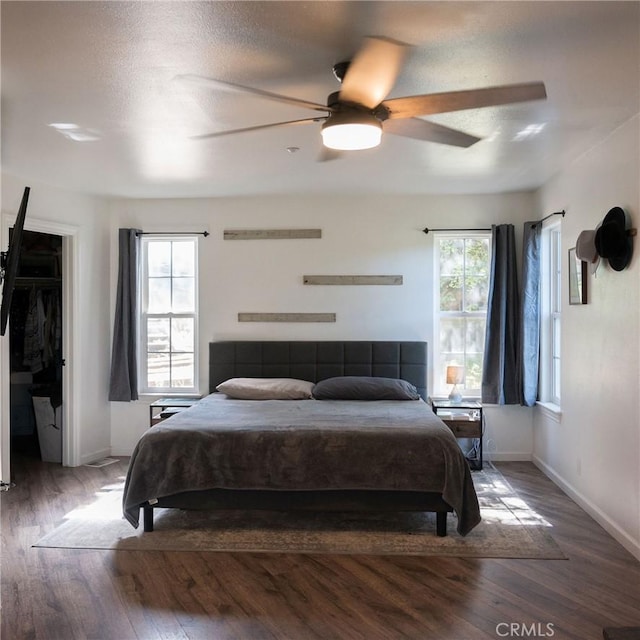 bedroom with multiple windows, ceiling fan, and hardwood / wood-style flooring