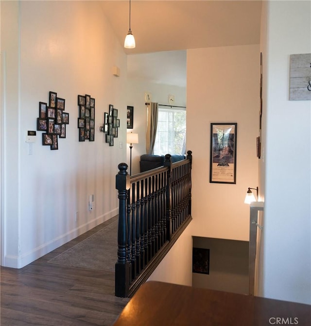 hallway with vaulted ceiling and dark wood-type flooring