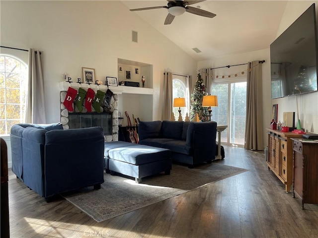 living room with a fireplace, high vaulted ceiling, ceiling fan, and dark wood-type flooring