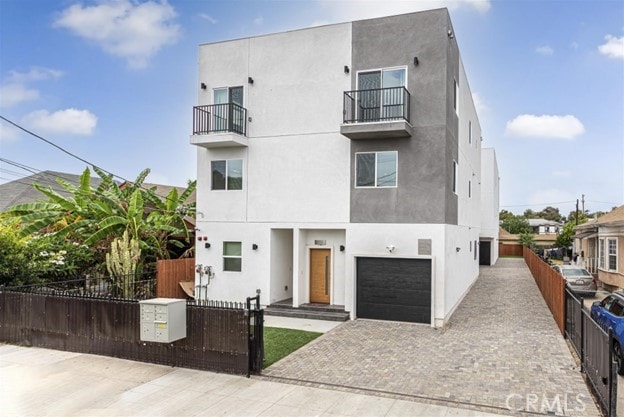 view of front of home featuring a balcony and a garage