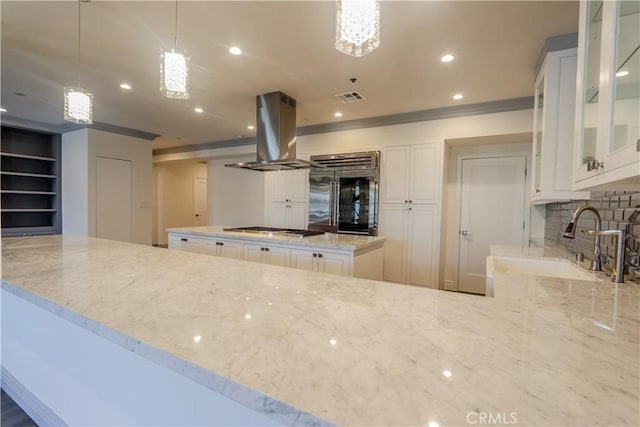 kitchen with hanging light fixtures, white cabinetry, island exhaust hood, and appliances with stainless steel finishes