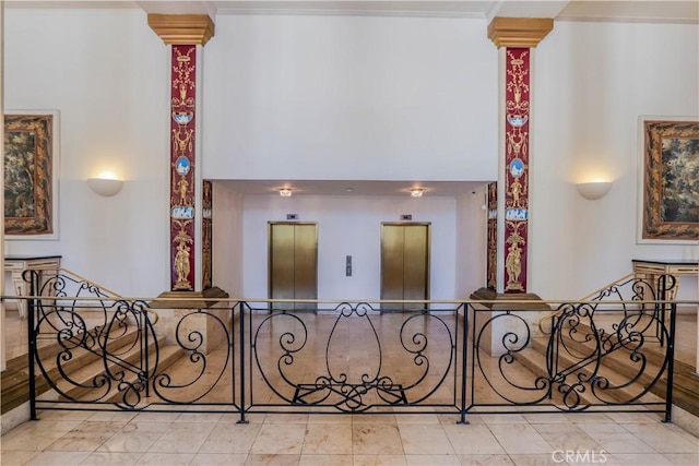 stairs with ornamental molding, elevator, and decorative columns