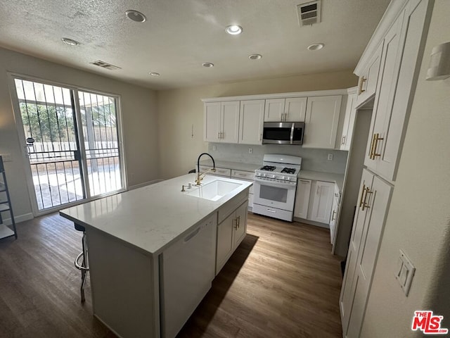 kitchen featuring sink, white appliances, a kitchen island with sink, white cabinets, and hardwood / wood-style flooring