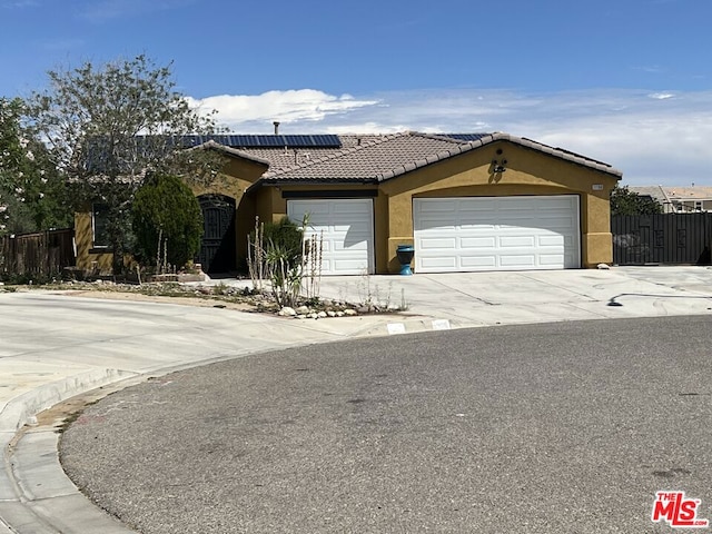 single story home with solar panels and a garage