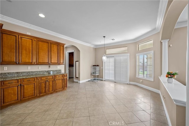 kitchen featuring pendant lighting, stone countertops, light tile patterned floors, and crown molding