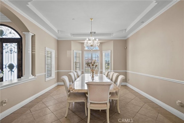 dining space featuring ornate columns, ornamental molding, a raised ceiling, light tile patterned floors, and a chandelier