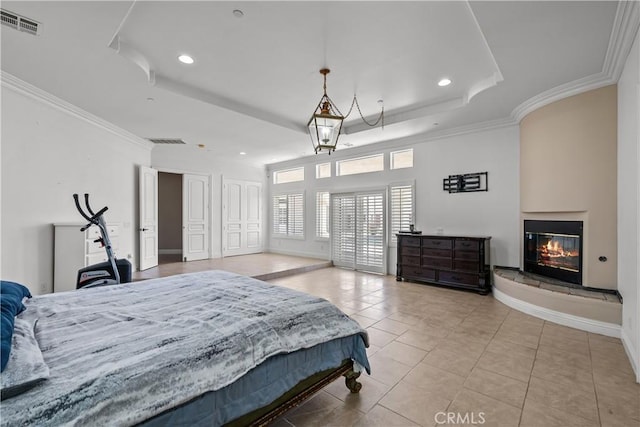 tiled bedroom featuring a tray ceiling and ornamental molding