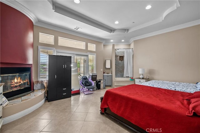 bedroom with light tile patterned floors, a tray ceiling, and crown molding