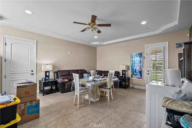 dining space featuring a tray ceiling, ceiling fan, and light tile patterned flooring