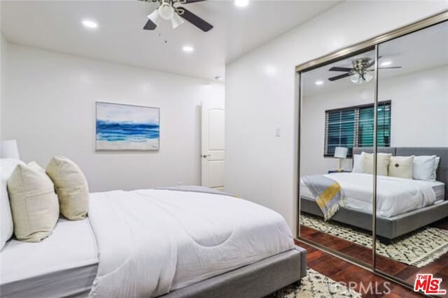 bedroom featuring ceiling fan, dark wood-type flooring, and a closet