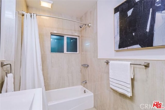 bathroom featuring shower / bath combo and tile walls