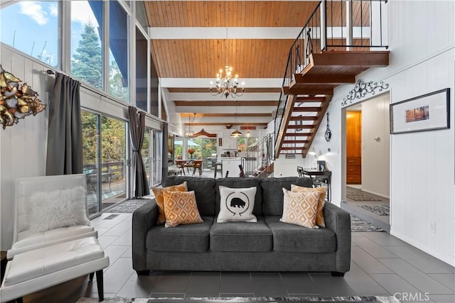 living area with a towering ceiling, wooden ceiling, stairway, a chandelier, and beam ceiling