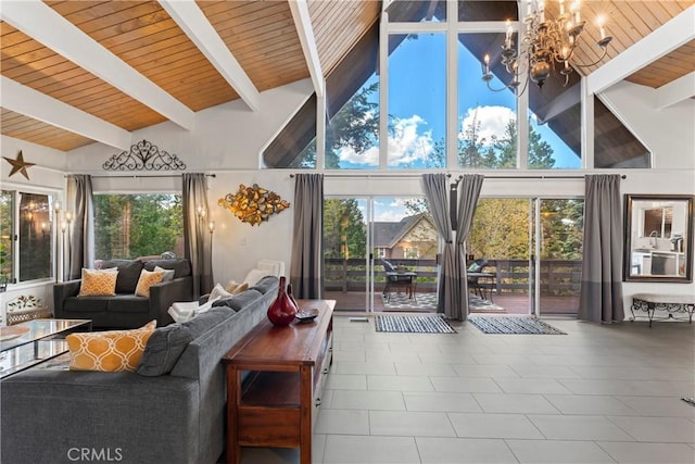 living room with a healthy amount of sunlight, an inviting chandelier, high vaulted ceiling, and beam ceiling