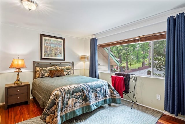 bedroom featuring baseboards and dark wood finished floors