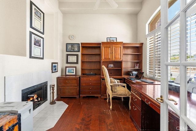 office space with a tile fireplace, french doors, dark hardwood / wood-style floors, and plenty of natural light