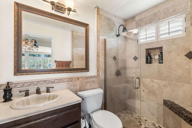 bathroom with vanity, a shower with shower door, tile walls, and toilet