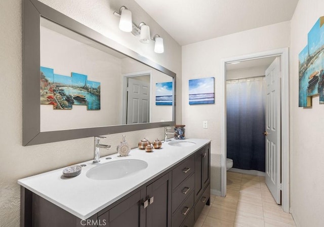 bathroom featuring tile patterned flooring, vanity, and toilet