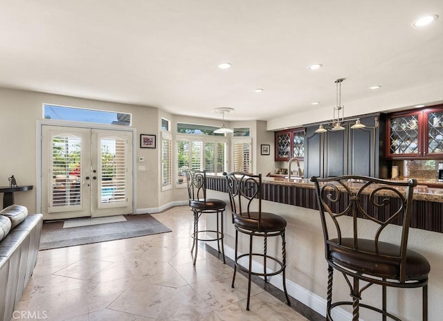 kitchen with french doors, hanging light fixtures, and a breakfast bar area