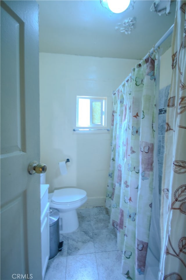 bathroom with tile flooring, toilet, and vanity