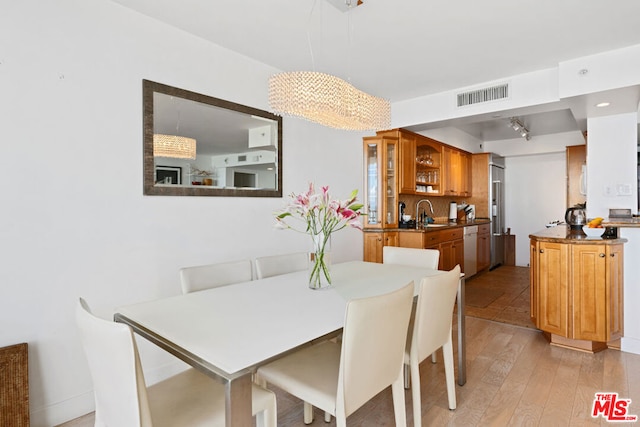 dining space featuring sink and light wood-type flooring