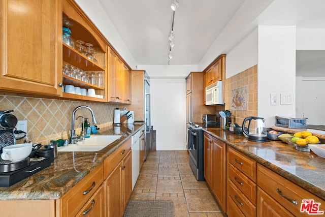 kitchen with white appliances, sink, tasteful backsplash, and rail lighting