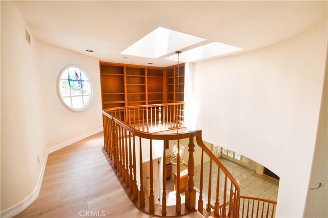 stairs featuring a skylight and hardwood / wood-style flooring