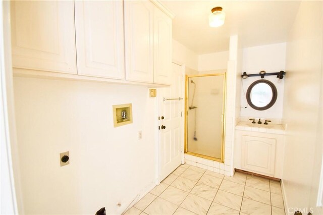 laundry room with hookup for a washing machine, cabinets, sink, and hookup for an electric dryer