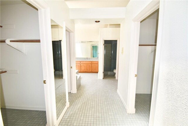 hall with light tile patterned floors and sink