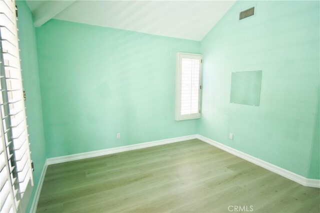 unfurnished room featuring vaulted ceiling and light wood-type flooring