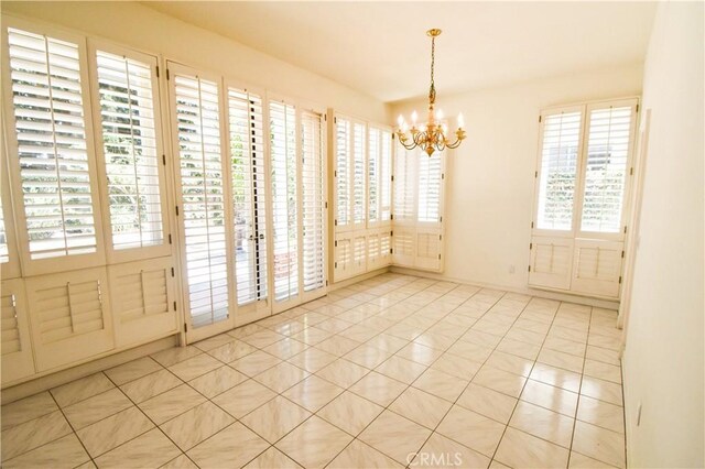 unfurnished room featuring light tile patterned floors and an inviting chandelier