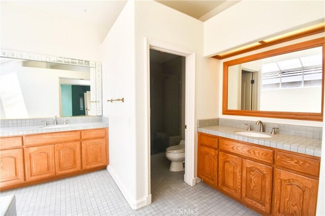 bathroom with tile patterned flooring, vanity, and toilet