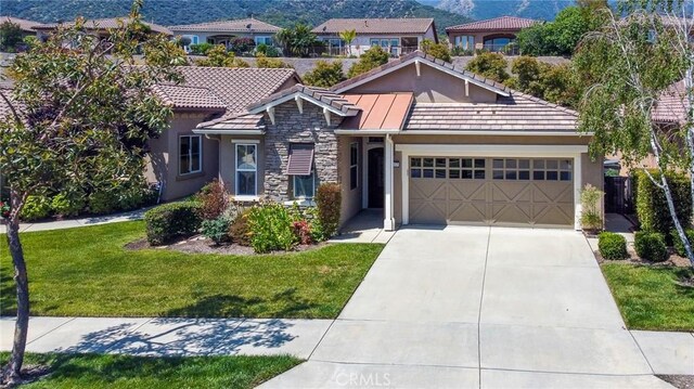 view of front of home with a mountain view, a garage, and a front yard