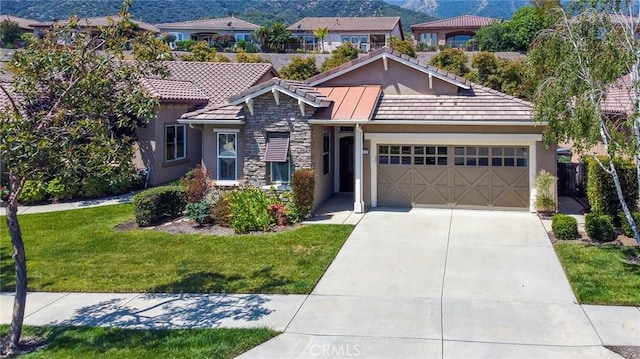 view of front of property featuring a garage, a mountain view, and a front lawn