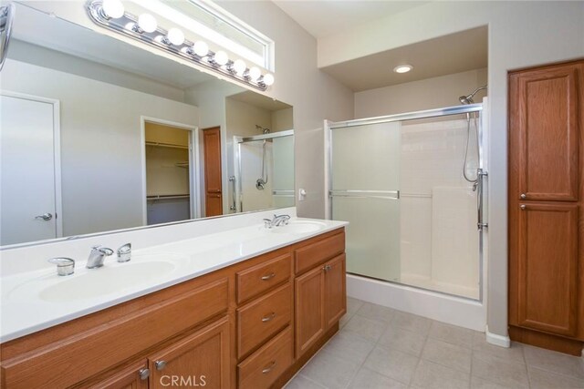 bathroom featuring a shower with door and vanity