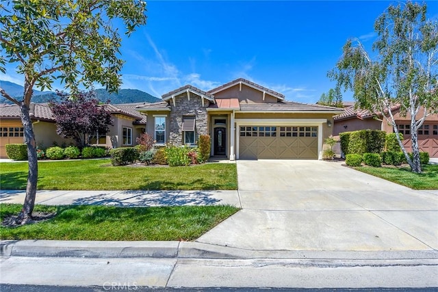 view of front of property featuring a mountain view, a front yard, and a garage